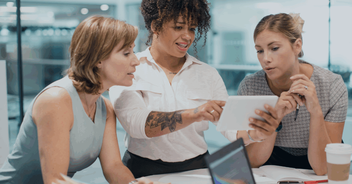 Team collaborating over a tablet while reviewing simulation results in a modern office.