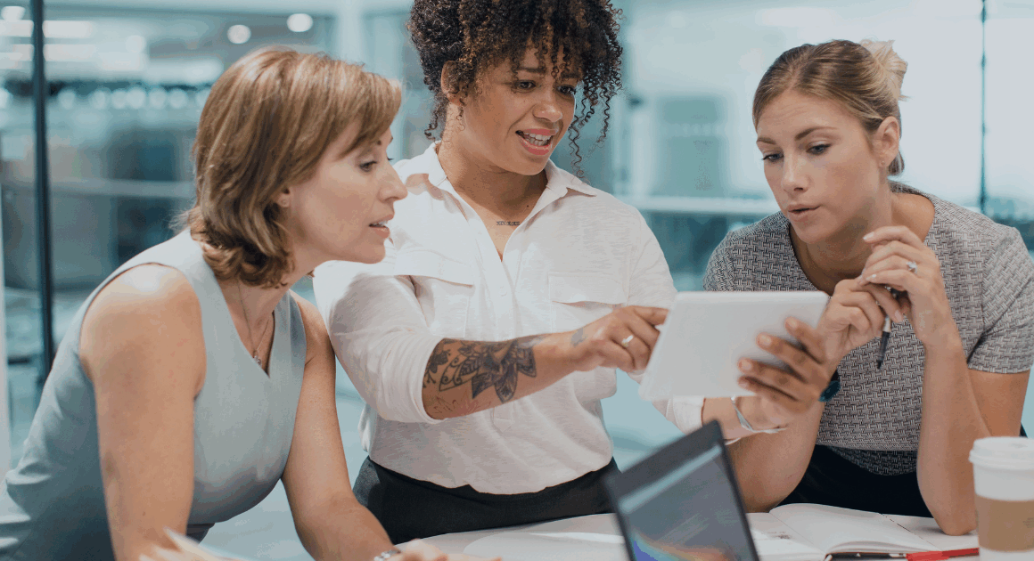 Team collaborating over a tablet while reviewing simulation results in a modern office.