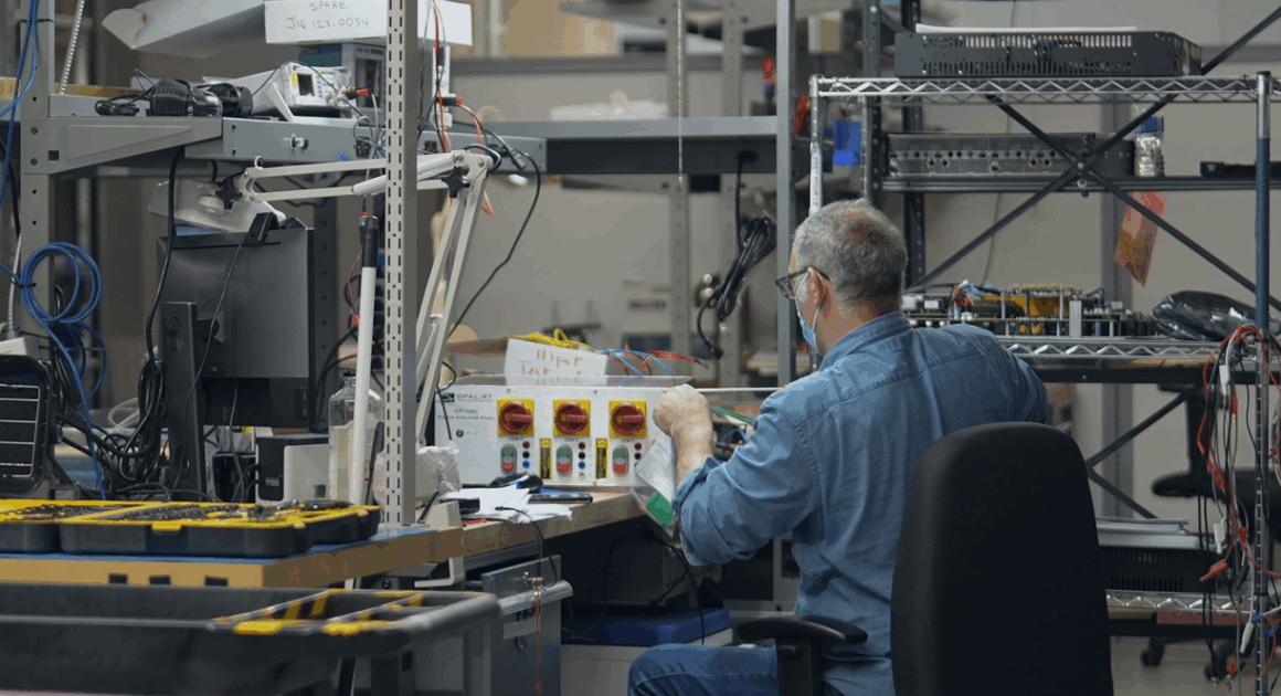 Engineer building real-time power simulation hardware for SPS integration in the OPAL-RT laboratory.